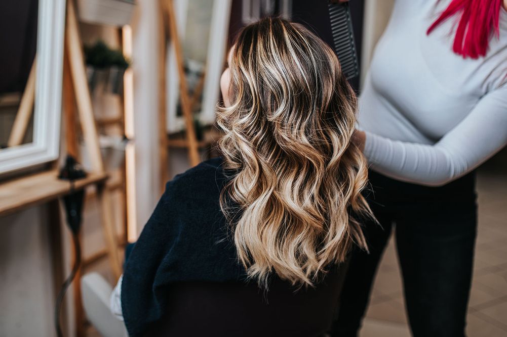 Eine Frau mit blonden Haaren bekommt ihre Haare gemacht