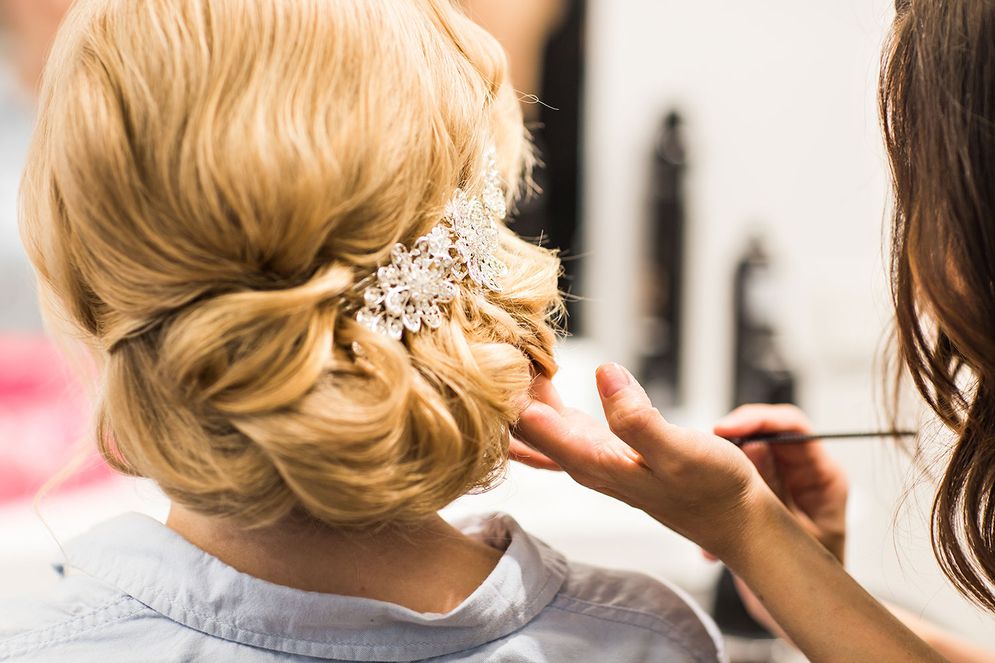 Eine Frau mit blonden Haaren bekommt ihre Haare für besondere Gelegenheiten vorbereitet
